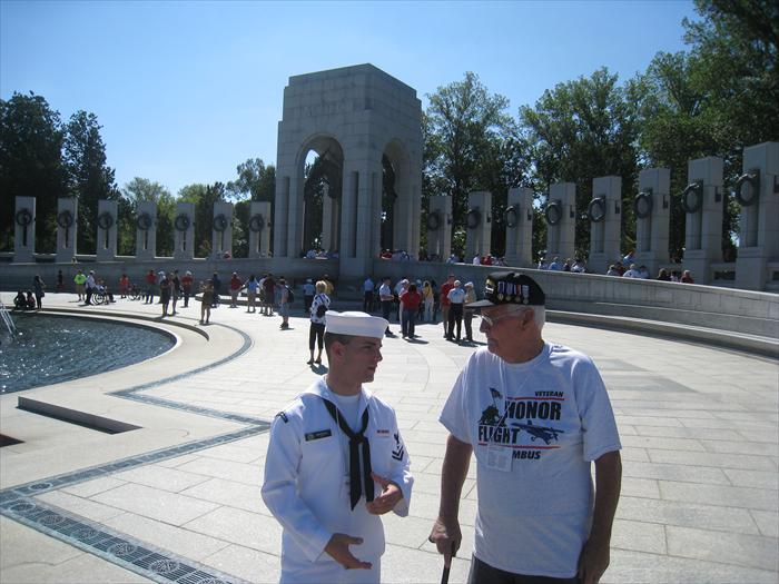 WW II Air Force Hero Bob Hickman shares some of his stories and memories with a young Merchant Marine while walking around the World War II Memorial.