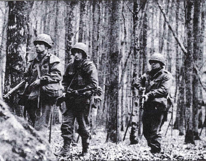 This is a picture from the 42nd infantry division book. We think my grandfather is in the middle. My grandfather said that he went through many forests that looks like this picture and often times a camera man was there taking pictures.