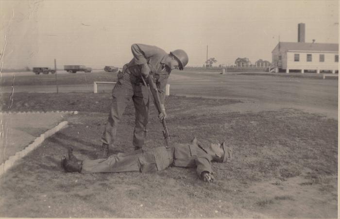 Dad wrote "That's me on the ground.  With my posing ability, I should be in Hollywood.  Ha! Ha!"
The famed guard house in the background.  This photo may have been taken further into Basic Training.  Note leaves on trees compared to other photos.
My dad's DD214 shows that he was promoted to a PFC January 28, 1952.  I found an article in "Stars and Stripes" that Privates were automatically promoted six months following Basic Training.  Based on this information, my dad completed Basic Training at Camp Breckinridge July 28, 1951.
It's possible he also had Advanced Training at Camp Breckinridge.  I await a confirmation.