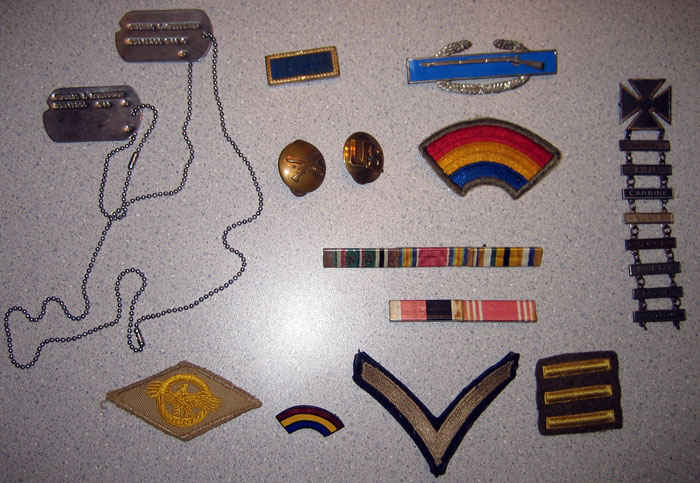 My grandfather's uniform accessories. Starting at the top left and going clockwise. Dog tags, presidential unit citation, infantry lapel, combat infantry badge, 42nd division (rainbow), qualification badges, ribbons, three 6-month overseas bars, private stripe, 42nd pin, and ruptured duck.