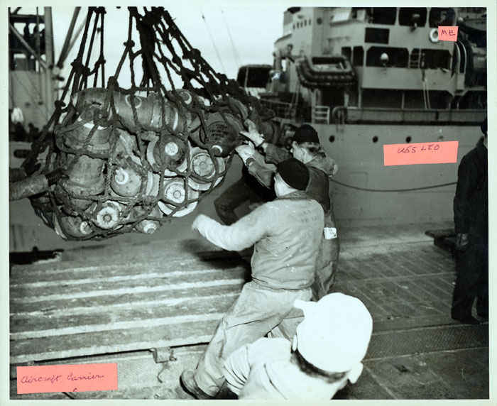 Loading bombs from the USS Leo to an Aircraft carrier. The men are standing on the Aircraft carrier and the USS Leo is in the background. If you look to the top left, you will see where my grandfather spent most of his time on the radio while ammunition was being loaded onto ships.